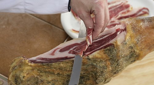 Primo piano di un tagliatore che taglia una spalla iberica